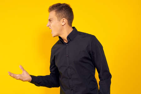 emotional man in black shirt lifestyle yellow isolated backgroundの写真素材