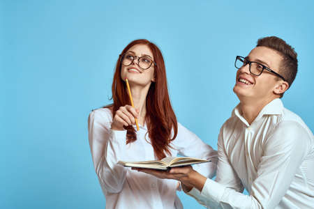 business woman and colleague man on a blue background in light clothes and documents in hands workの写真素材