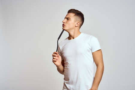 Guy with kitchen tools in hands on a light background cropped view of emotions fun modelの写真素材