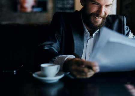 business man sitting at a table in a cafe documents work official coffee cupの写真素材