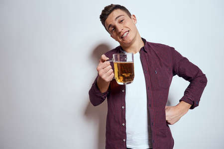 Cheerful man with mug of beer alcohol emotions light background