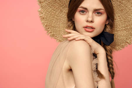 Portrait of a girl in a straw hat on a pink background emotions close-up beautiful face model...