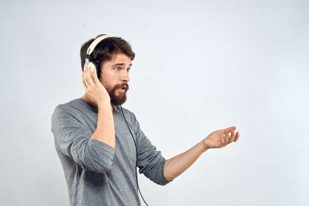Man in headphones listens to music lifestyle modern style technology light backgroundの写真素材