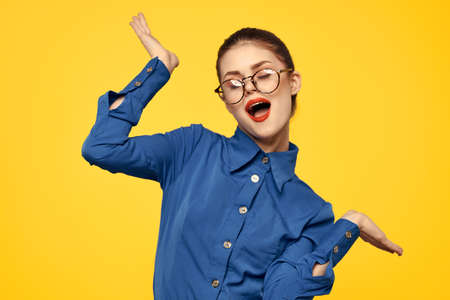 woman with glasses and blue shirt gesturing with her hands on yellow background cropped view Copy Spaceの写真素材