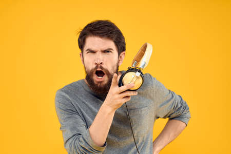 Man in headphones listens to music technology lifestyle fun people yellow backgroundの写真素材