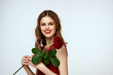 Pretty woman with rose in her hands charm gift lifestyle studio light backgroundの写真素材