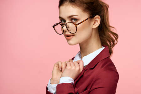 Business woman red jacket glasses executive lifestyle studio pink backgroundの写真素材