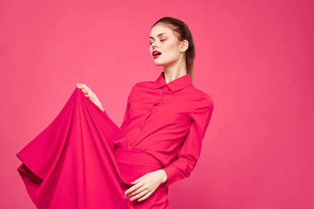 Woman on a pink background in fashionable clothes and bright makeup hairstyle model Copy Spaceの写真素材