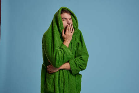A man with a head hid in a green robe on a blue background cropped view of Copy Spaceの写真素材