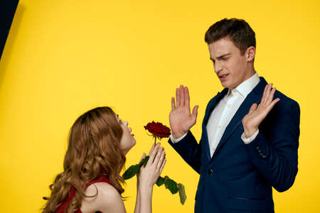 Young charming couple rose relationship romance gift as a lifestyle yellow isolated backgroundの写真素材