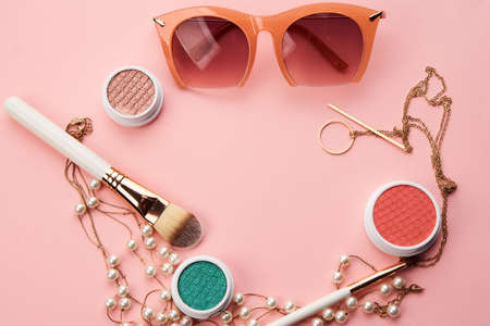 cosmetics on pink background eyeshadow brush powder blush clockの写真素材