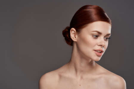 Beautiful woman naked shoulders cosmetics clean skin charm gray background studioの写真素材