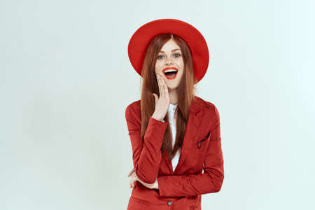 beautiful woman in red hat blazer makeup elegant style light background studioの写真素材