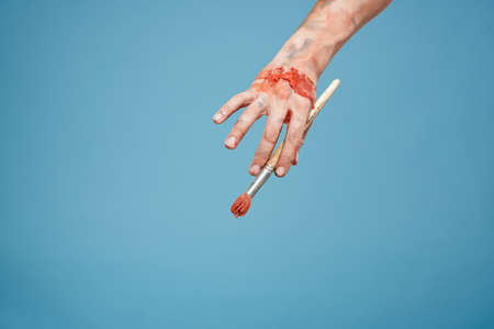 Artists hands paint close-up blue background drawing hobbyの写真素材