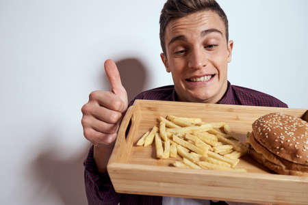Man eating wooden pallet fast food french fries hamburger diet food restaurant light background