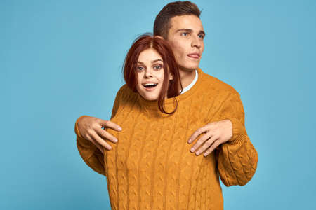 couple in love in yellow sweater posing against blue background cropped view Copy Spaceの写真素材