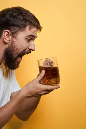 Man with a mug of beer fun alcohol lifestyle white t-shirt yellow isolated background
