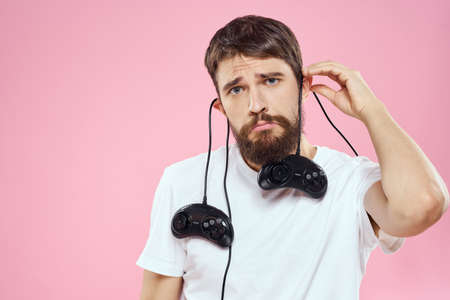 Man with two joysticks in hands fun game technology lifestyle pink backgroundの写真素材