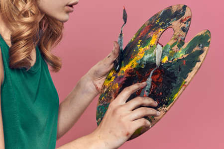 Woman artist green dress easel eat drawing art pink backgroundの写真素材