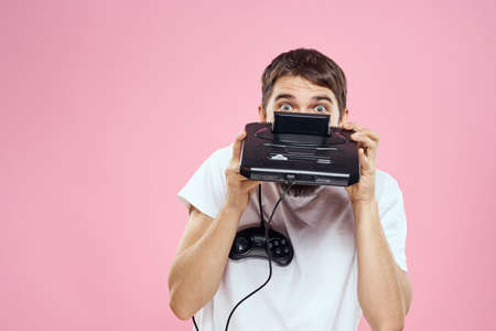 Man with prefix in hand joystick games lifestyle fun pink background white t-shirtの写真素材