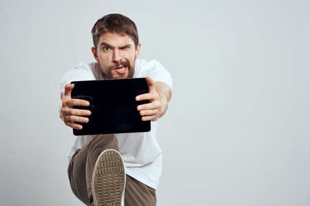 emotional man with tablet in hand touch screen new technologies light background cropped view Copy Spaceの写真素材