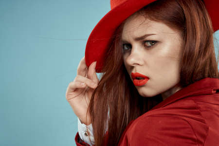 Beautiful elegant woman red lips hat on head close-up glamor blue backgroundの写真素材