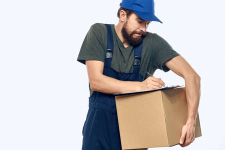 Man in working uniform box delivery loader courier light background