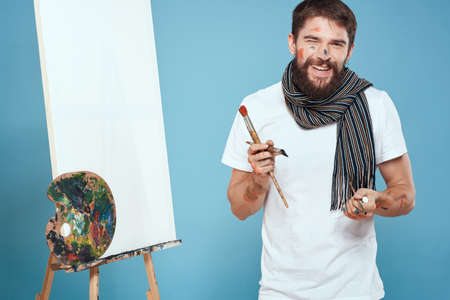 Male artist palette brush easel art hobby blue backgroundの写真素材
