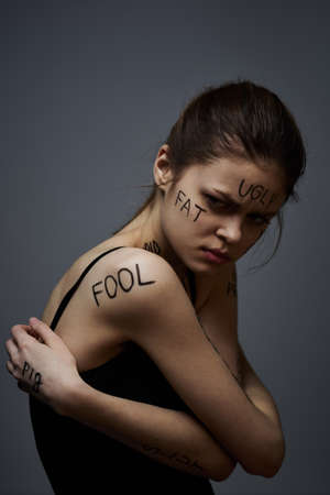 Woman with inscriptions on the body frustration and dissatisfaction emotions lifestyle gray backgroundの写真素材