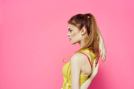 Sportive woman jumping rope friend exercise yellow tank top workout pink backgroundの写真素材