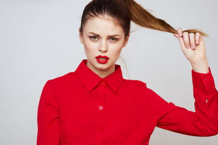 portrait of a woman with red lips in a shirt on a light background cropped view model makeup hairstyleの写真素材