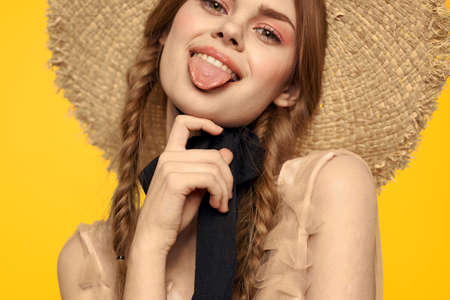 Romantic woman in hat having fun on a yellow background and sunglasses black ribbon model portraitの写真素材