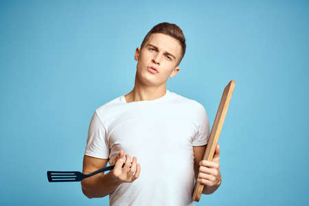 energetic guy with wooden kitchen board and spatula fun emotionsの写真素材