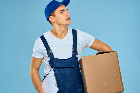 Man worker with cardboard box delivery loader lifestyle blue background