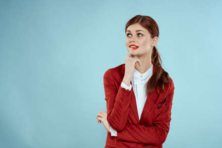 Elegant woman in red jacket bright makeup lips self-confidence cropped view blue backgroundの写真素材