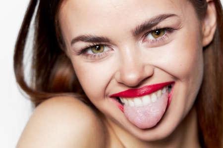 Cheerful woman shows tongue face close up joy