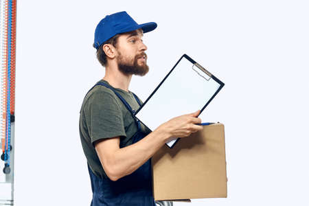 Working male courier with box in hand documents delivery service light background