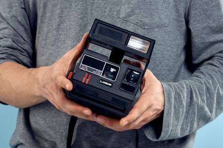 Photo camera in the hands of a man professional shooting lens technology studio equipment blue...