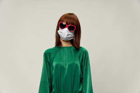 Woman in fashion dress posing in medical mask virusの写真素材