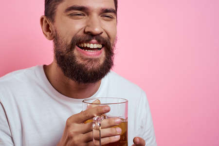 Bearded man with a mug of beer On a pink background fun emotions cropped view of a white T-shirt drunkの写真素材