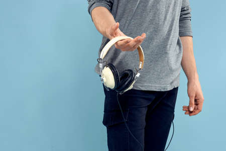 Man holding headphones in his hands music lifestyle technology blue background