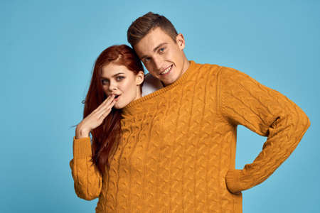 couple in yellow sweater posing against blue background cropped viewの写真素材