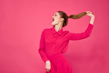 Portrait of a red-haired woman in bright clothes on a pink background cropped view of gesturing with her handsの写真素材