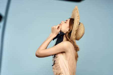 Romantic girl in a straw hat on a gray background and a beige sundress black ribbon emotions modelの写真素材