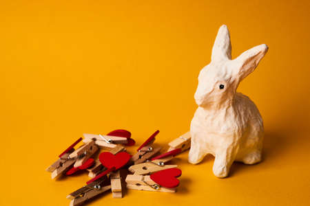 Easter bunny and hearts on clothespins on a yellow background close-upの写真素材