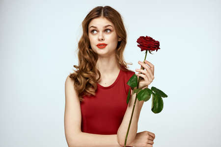 Pretty woman with rose in her hands charm gift lifestyle studio light backgroundの写真素材