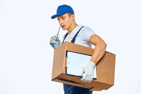 Man worker with box in hands delivery loading service work light background