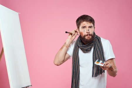 painter holding palette drawing art easel hobby creativity pink backgroundの写真素材