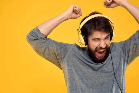 Man with headphones music lifestyle lifestyle technology yellow background