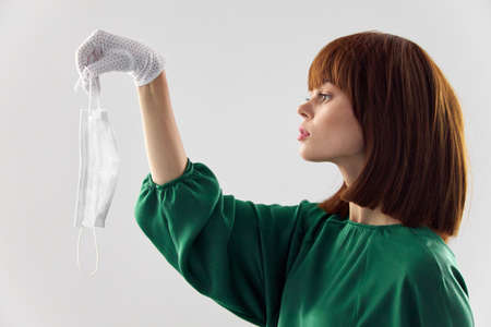 Woman in fashion dress posing in medical mask virusの写真素材